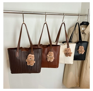 Macro shot of large woven tote bags in four colors with cute brown teddy bear charms