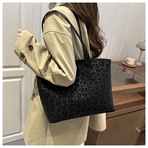 Detail of leopard print velvet tote bag with slim shoulder strap on female model
