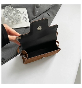 Detail of dark brown matte leather handbag showing the magnetic silver snap closure