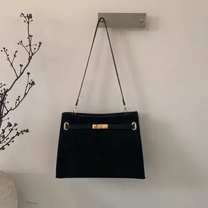 Große schwarze Wildledertasche mit goldenem Drehverschluss und feinen Schulterriemen