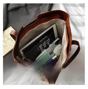 Interior view of large capacity brown woven tote bag showing space for iPad and books