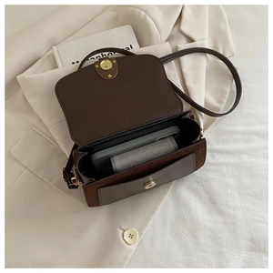 Detail view of brown crossbody bag showing spacious interior with phone and wallet