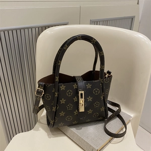 Minimalist tote bag with star patterns and gold lock shown on an armchair in a home setting