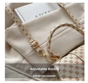 Close-up of adjustable golden metal buckle on floral print cream shoulder bag