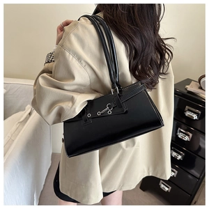 Sac baguette rétro noir avec boucle métallique présenté dans un cadre de bureau lifestyle