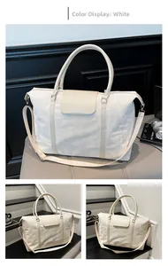 Detail view of large white travel bag with pleated texture and adjustable shoulder strap
