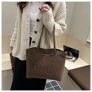 Detailed close-up of brown leopard print suede tote bag with slim shoulder straps