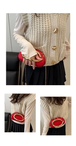 Detail of red pod-shaped bag with large gold ring handle and metal chain strap