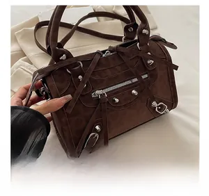 Detail view of brown vintage motorcycle bag with silver rivets and long tassel zippers