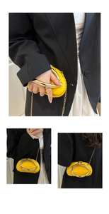 Detailed views of yellow lychee leather oval bag with gold metal ring handle and chain