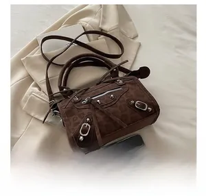 Detail view of brown leopard print crossbody bag with studs next to a smartphone for scale