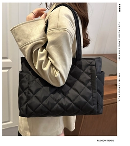 Detailed close-up of black quilted puffer tote bag with diamond lattice pattern and soft texture