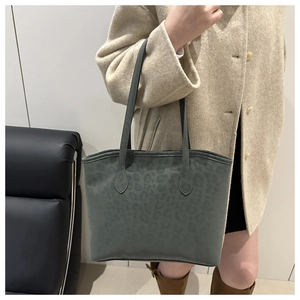Detail of stylish leopard print tote bag styled with beige coat for minimalist daily wear