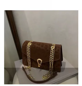 Close-up of brown leopard print texture on crossbody bag with gold horseshoe buckle