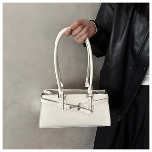 Détail du sac à main crème avec ceinture décorative et boucle métallique élégante