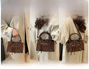 Brown suede crossbody bag detail showing silver rivets, long tassels and leather handle