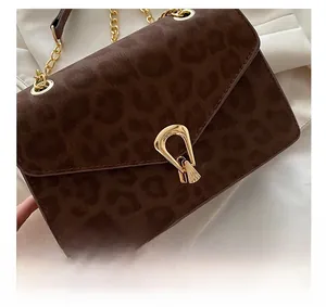 Close-up of leopard print crossbody bag with gold chain strap and vintage metal lock