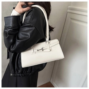 Detailed view of white faux leather shoulder bag with fine litchi grain and silver buckle