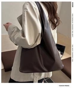 Detailed view of dark brown soft leather tote bag showing smooth PU material and wide strap