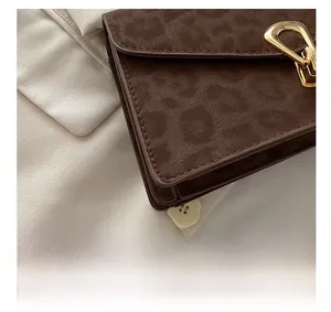 Detail shot of leopard print faux suede fabric with gold metal buckle and stitching