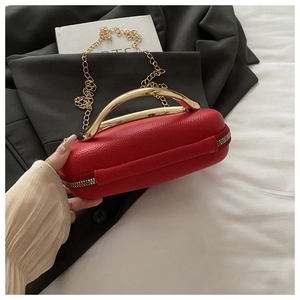 Detail of red lychee grain box bag with curved golden metal handle and chain strap