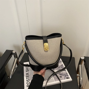 Contrast stitching canvas bucket bag with black leather trim and gold hardware