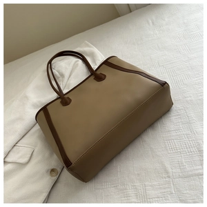 Detail of khaki and dark brown contrast tote bag with premium leather texture on white grid