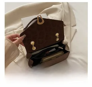 Detail showing the spacious interior and gold chain hardware of a leopard print bag
