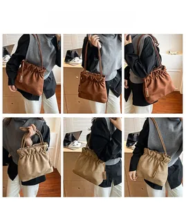 Detailed views of brown and beige suede bucket bags with pleated drawstring and metal charm