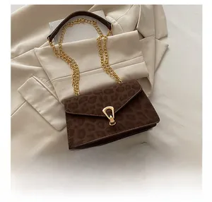 Detailed view of leopard print shoulder bag with gold clasp and phone for size reference