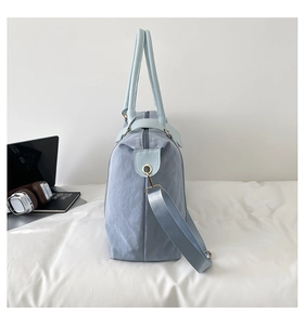 Detail of light blue nylon travel bag with waterproof texture and metal buckle
