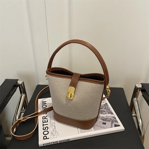 Canvas and brown leather bucket bag with gold clasp and adjustable strap for women