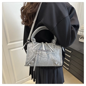 Detail of grey leopard texture handbag with silver studs and long leather tassels