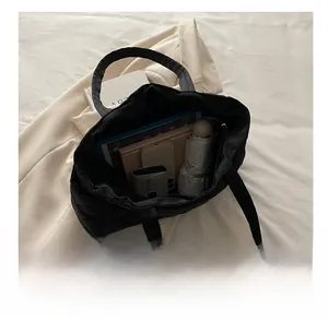 Macro shot showing large storage capacity of black quilted tote bag for daily commute