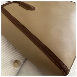 Close-up of contrast stitching and premium khaki leather texture on large tote bag