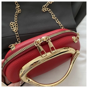 Detailed close-up of red lychee grain leather crossbody bag with gold chain and handle