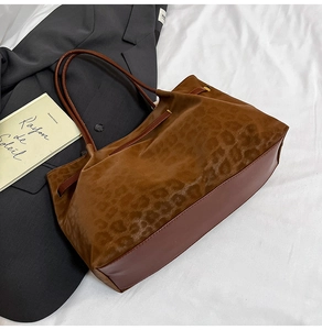 Detailed view of leopard print suede and leather stitching on a retro tote bag