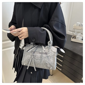 Detail of grey leopard print handbag with metal studs and tassel in motor style