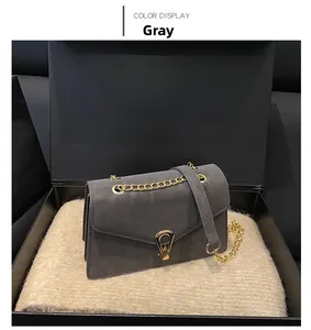 Detail of grey matte leather shoulder bag with gold chain strap and metal lock