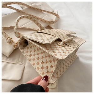 Side view of retro monogram crossbody bag with accordion folds and refined stitching