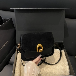 Elegant black flap crossbody bag with golden horseshoe buckle in a premium gift box