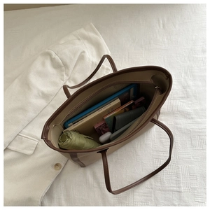 Spacious interior of khaki tote bag holding an umbrella, tablet, book, and wallet