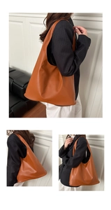 Detail view of large brown faux leather tote bag showing texture and slouchy drape