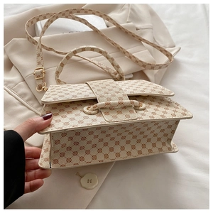Detail of beige vintage floral square bag with adjustable strap on neutral fabric