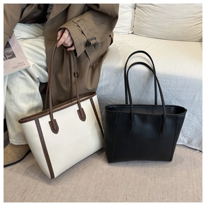 Detail of large tote bags in solid black and cream-brown contrasting colors for commute