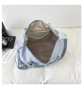 Internal view of light blue travel bag showing spacious beige lining and inner pocket