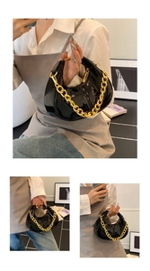 Detailed view of black patent leather hobo bag with a thick decorative gold chain