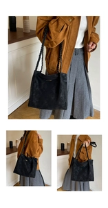 Detail of black faux suede tote bag featuring distinctive double-braided shoulder straps