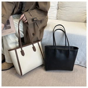 Detail of minimalist large capacity tote bag with long shoulder straps in a premium setting
