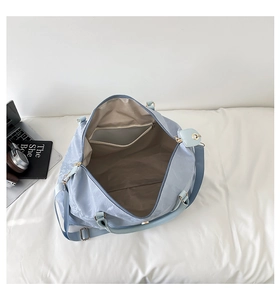 Internal view of spacious light blue travel bag with zip pocket and gold hardware
